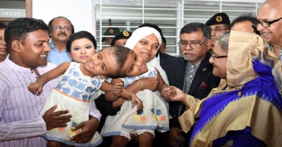 জোড়া মাথার দুই শিশুর পাশে প্রধানমন্ত্রী